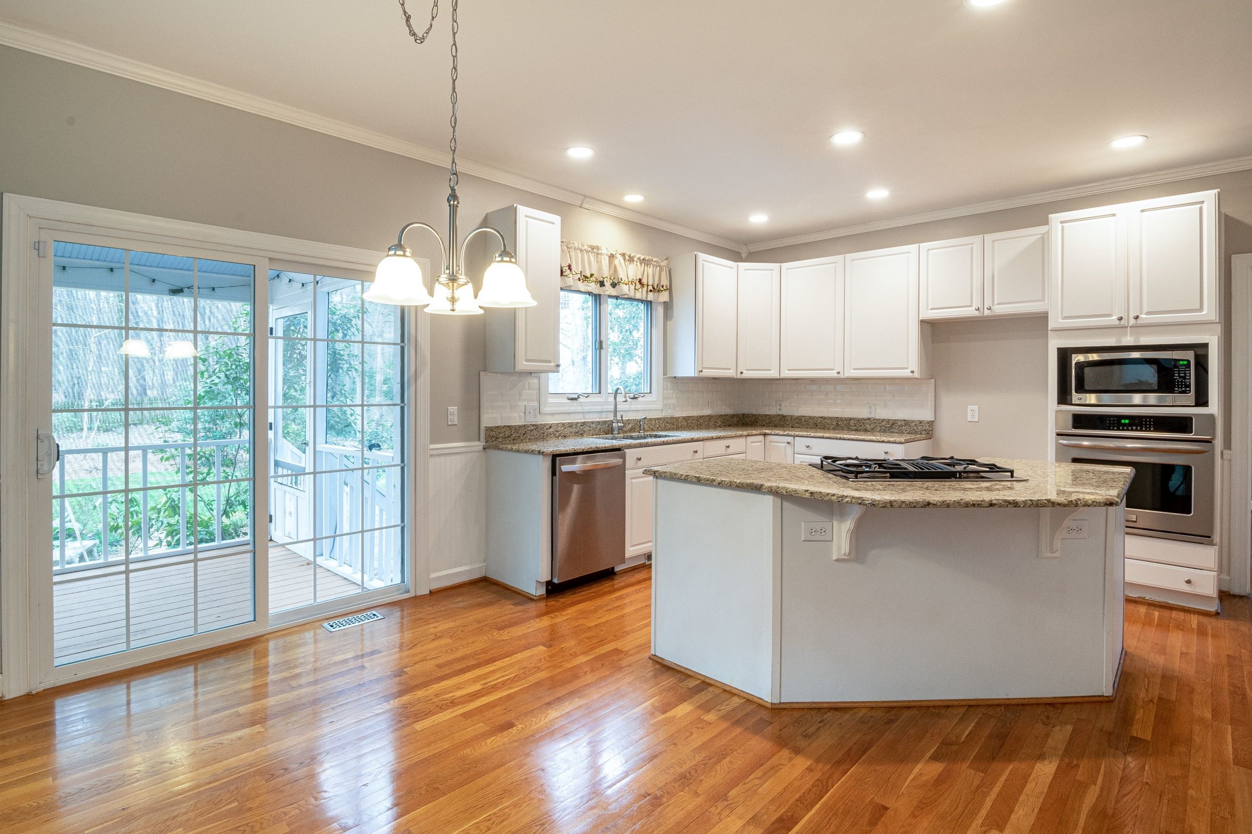 This image depicts a beautiful kitchen with an island and sliding patio doors.