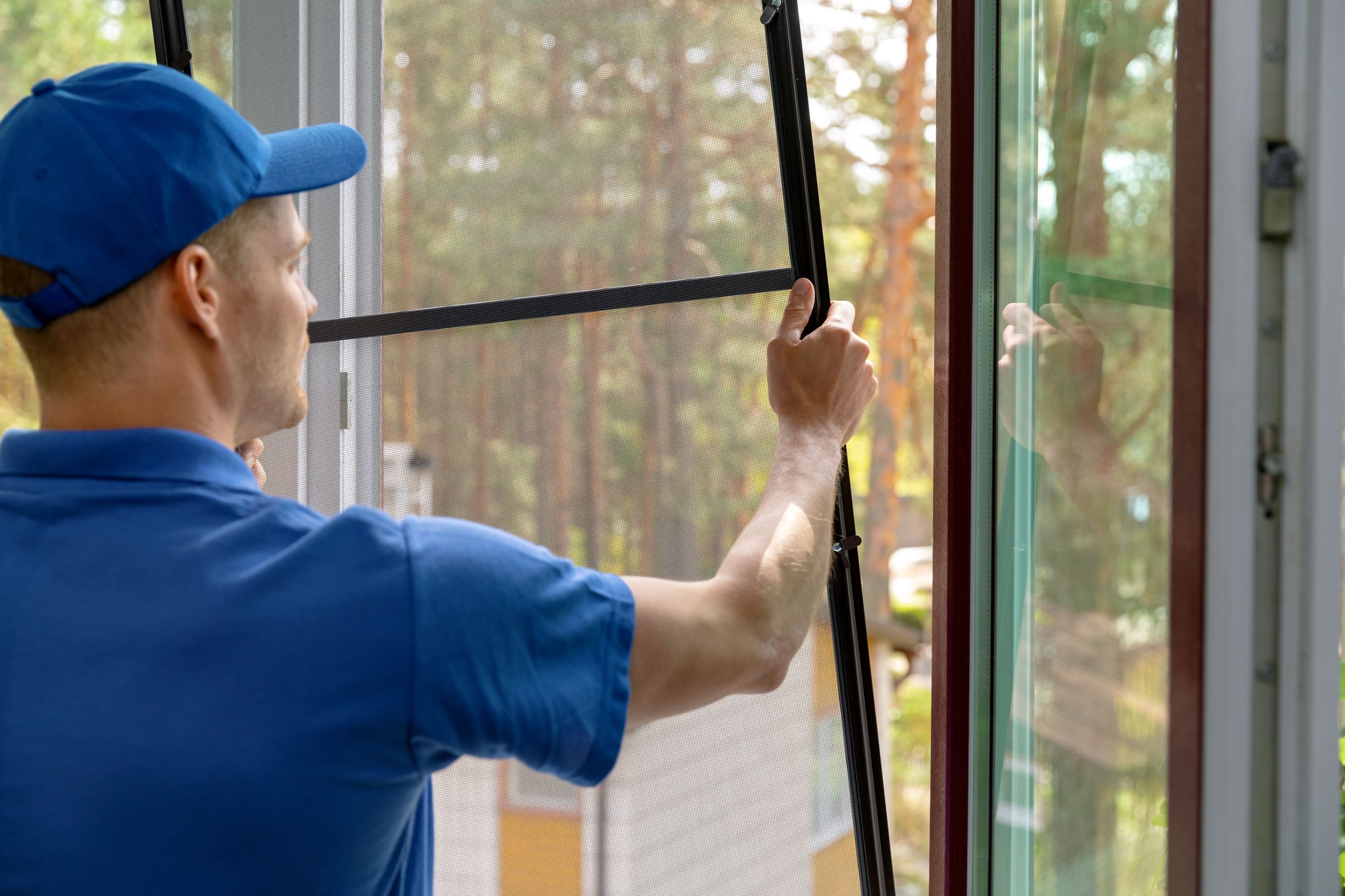 Here are a few tips to help you find the best window installation company in Michigan for your needs. In this image, a man is removing or placing a window screen.